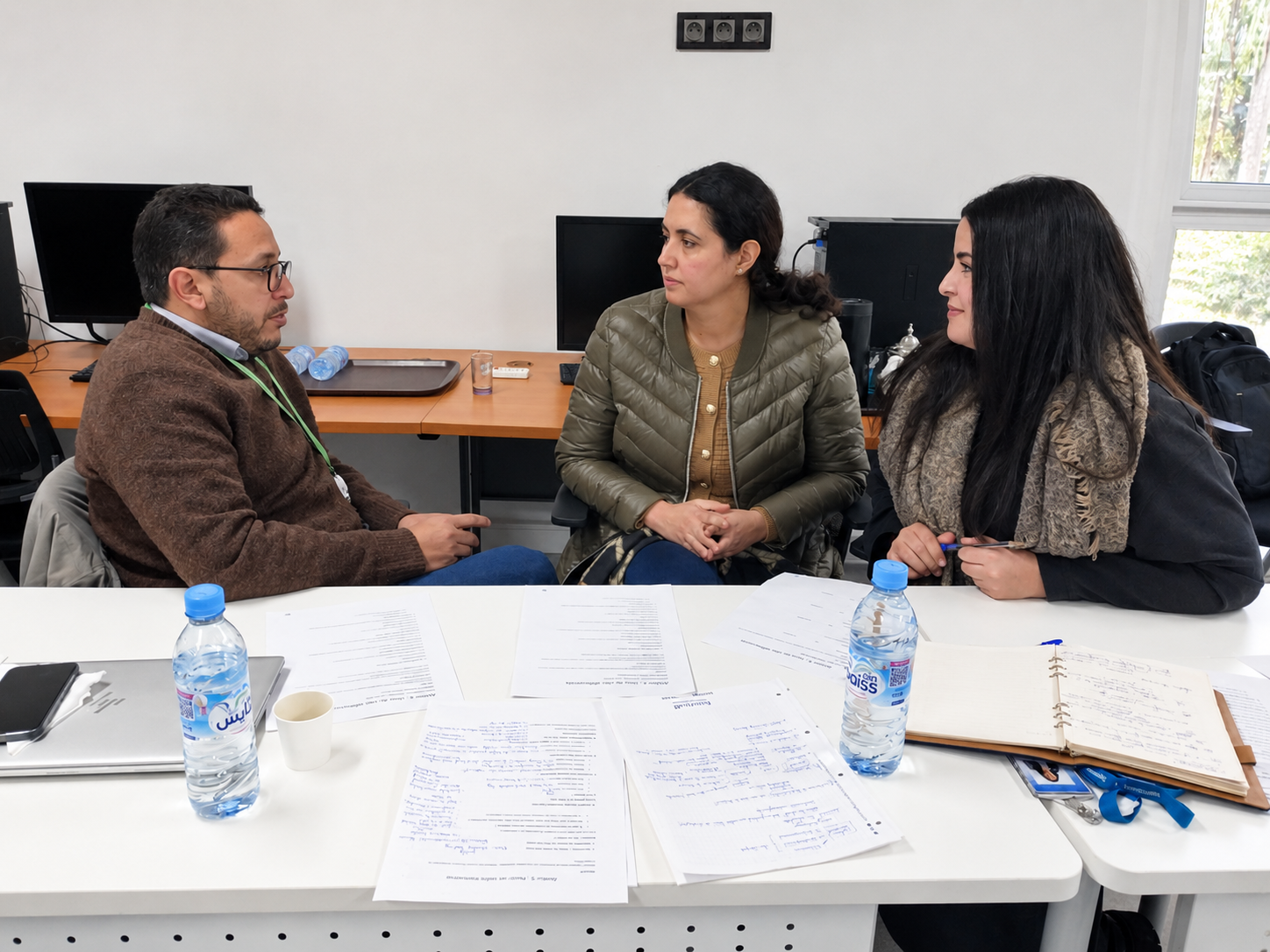 Échange de coaching professionnel en petit groupe autour d'une table de travail